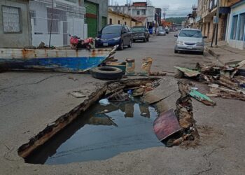 Voz Comunitaria | Vecinos de la calle Perú cerraron la vía para evitar que sigan cayendo carros en un socavón